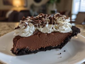 A decadent slice of Christmas chocolate cream pie featuring rich filling, whipped cream, and chocolate shavings.