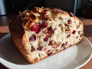 Close-up view of the interior crumb of cranberry walnut bread, showing dried cranberries and walnuts baked into the light dough.