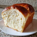 Close-up of a freshly baked milk bread loaf, showing its incredibly soft, white, and fluffy interior crumb.