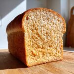Close-up of a freshly baked whole wheat bread loaf showing a soft, airy crumb texture.