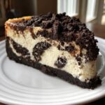 A beautiful slice of creamy oreo cheesecake with a dark chocolate crust and generous chocolate crumb topping.