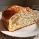 Cross-section of a soft, homemade French bread loaf showing the fluffy white crumb and golden crust.