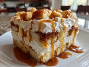 A decadent slice of caramel apple trifle featuring layers of cake, cream, and generous caramel drizzle.