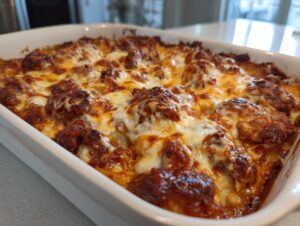Close-up of a hot, bubbling pierogi casserole dish topped with melted, browned cheese.