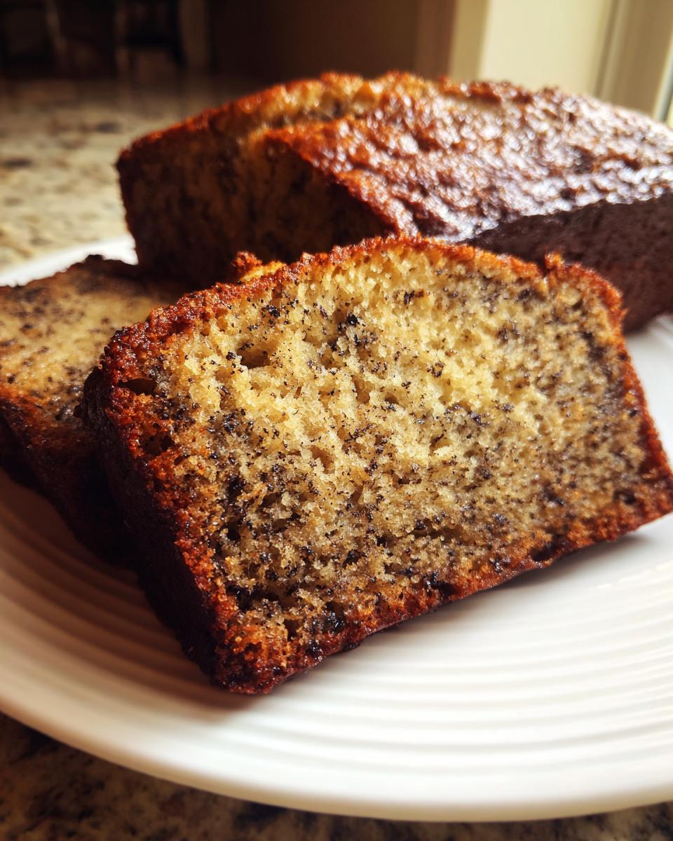 Close-up of moist slices of the best banana bread showing dark specks of mashed banana.